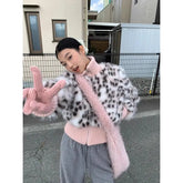 Person wearing a leopard print coat with pink trim and gloves, standing on a street.